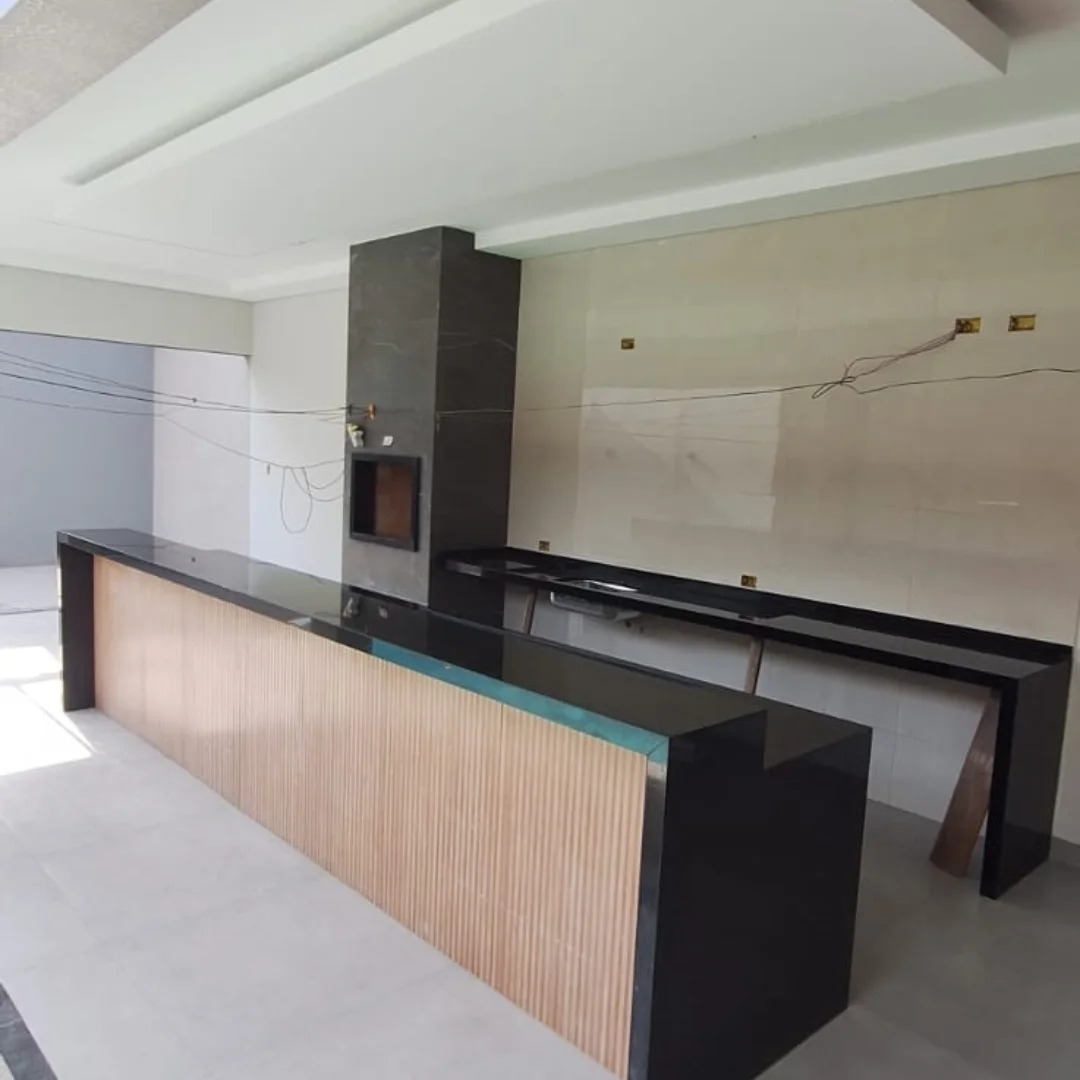 Bancada gourmet em granito preto com churrasqueira revestida